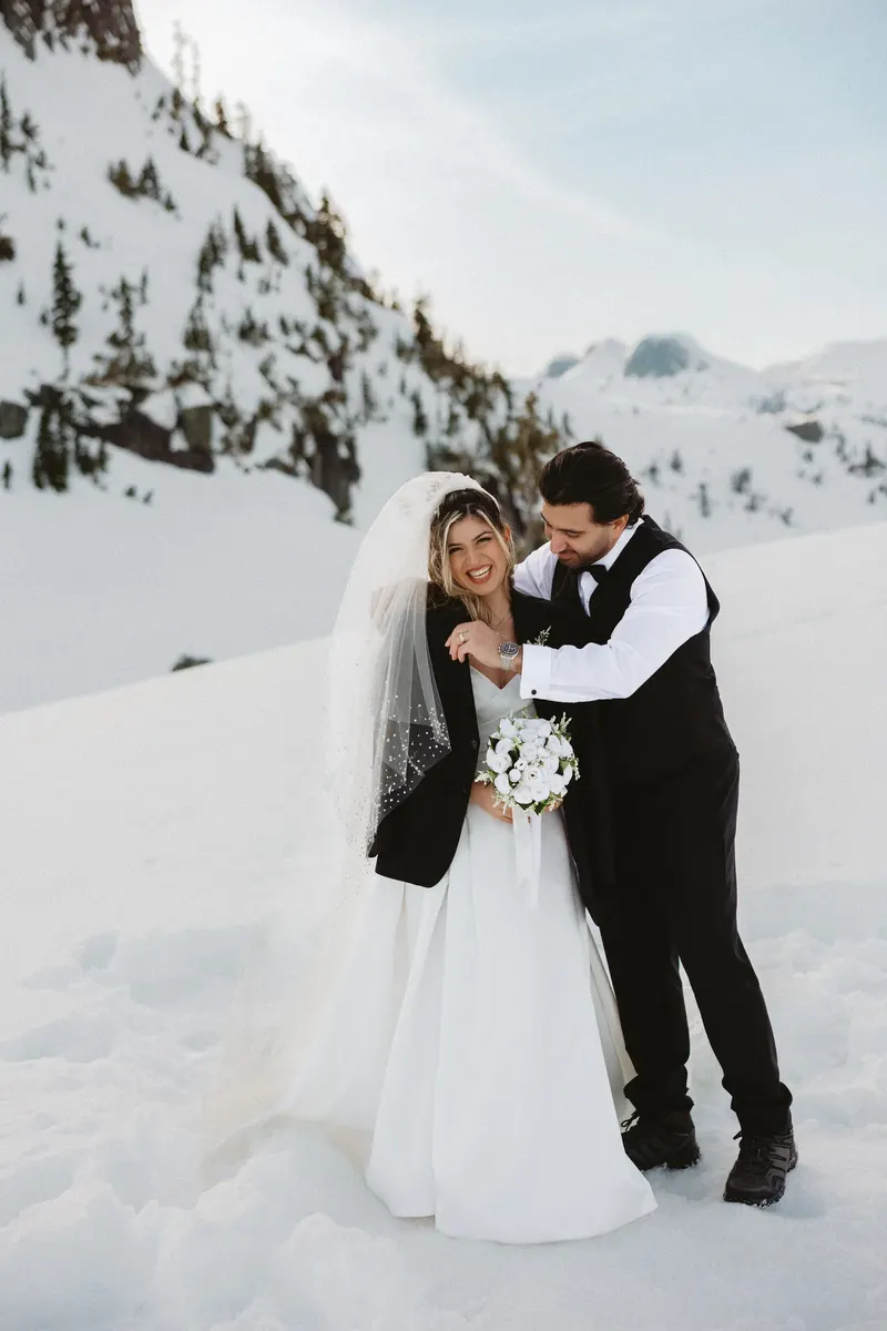 Groom hugging the laughing bride in the snow