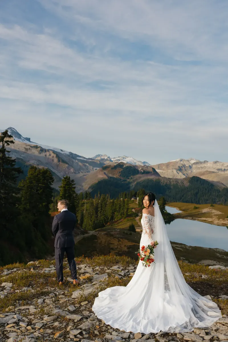 Couple beside an alpine lake ringed by mountains