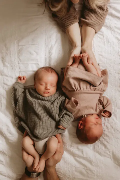 Two newborns sleeping side by side