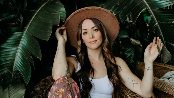 Stacey smiling in a wide-brim hat