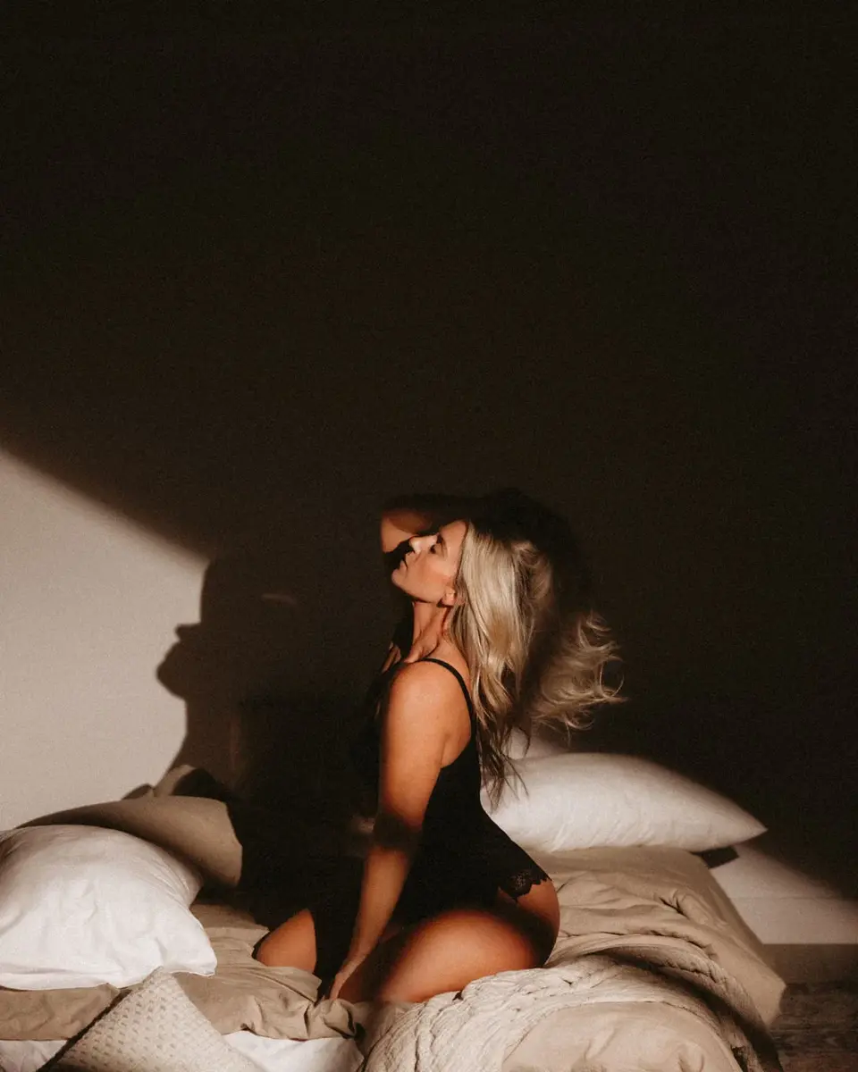 Boudoir portrait in dramatic bedroom light