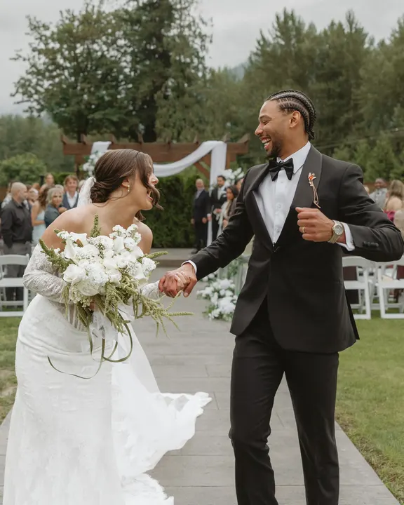 Bride and groom laughing as they head back down the aisle