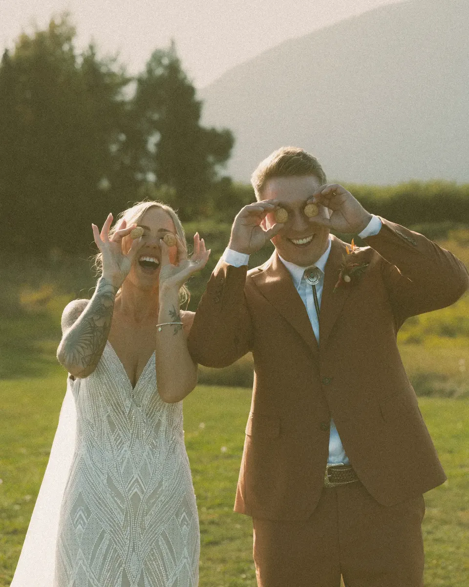 Bride and groom making goofy glasses with their fingers