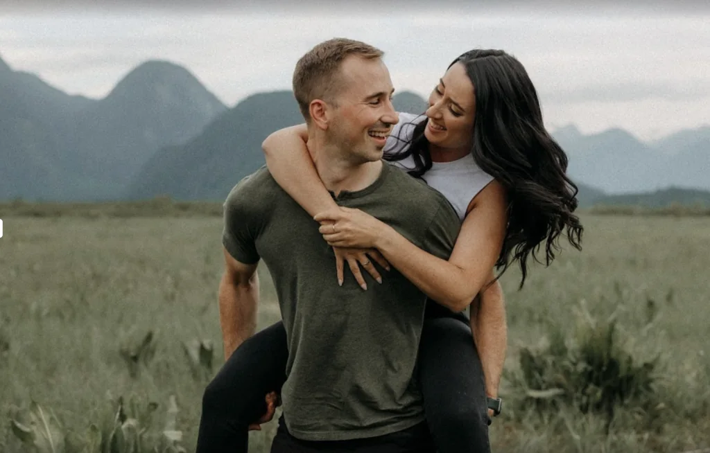 Couple laughing together in a mountain field